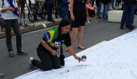 Durante o ato foi estendida uma faixa branca para que os manifestantes registrassem seus protestos (Foto: Cristina Indio do Brasil/Agência Brasil) Durante o ato foi estendida uma faixa branca para que os manifestantes registrassem seus protestos (Foto: Cristina Indio do Brasil/Agência Brasil)