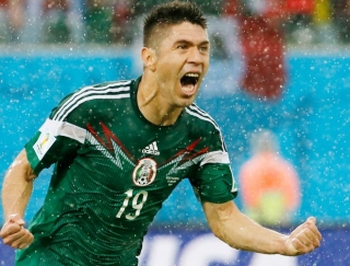 Debaixo de chuva, Peralta comemora gol mexicano no confronto contra CamarÃµes (Foto: Reuters)