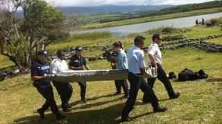 O momento em que as autoridades transportam o pedaço de asa encontrada nos destroços que deram à costa da ilha, situada no Oceano IndÃco (Imagem retirada do blogue PeurAvion) O momento em que as autoridades transportam o pedaço de asa encontrada nos destroços que deram à costa da ilha, situada no Oceano IndÃco (Imagem retirada do blogue PeurAvion)