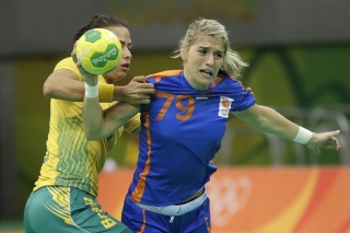 Fernanda tenta parar Estavana Polman no ataque (Foto: AP Photo/Matthias Schrader)